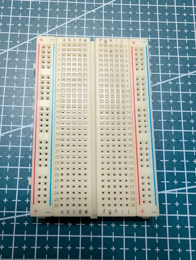 Close-up of a solderless breadboard showing the center gap and power rails.
